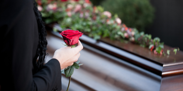 Person with a rose in hand at a funeral